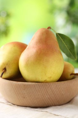 Taze olgun armutlar beyaz masada kasede, yakın plan.