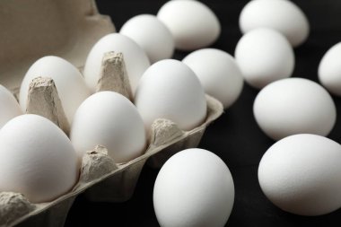 Siyah masada bir sürü çiğ tavuk yumurtası, yakın plan.