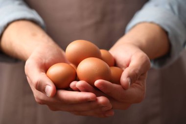 Bir sürü çiğ tavuk yumurtası olan adam, yakın plan.