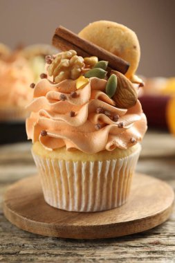 Gri arka planda, ahşap masada serpiştirilmiş fındıklı, kurabiyeli ve baharatlı enfes kek, yakın plan. Sonbahar atmosferi