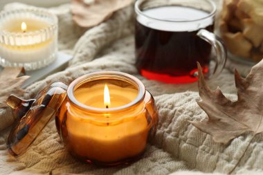 Yakıcı mumlar ve ekoseli çay, yakın plan. Sonbahar atmosferi