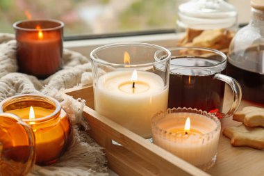 Yağmurlu bir günde pencere eşiğinde mum ve çay yakmak, yakın plan. Sonbahar atmosferi