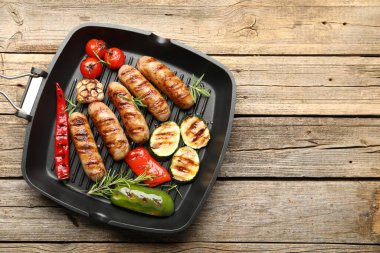 Tavada ızgara sosis, sebze ve baharat, ahşap masa, üst manzara. Metin için boşluk