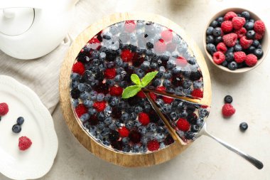 Açık gri masada böğürtlenli ve nane şekerli nefis peynirli kek.