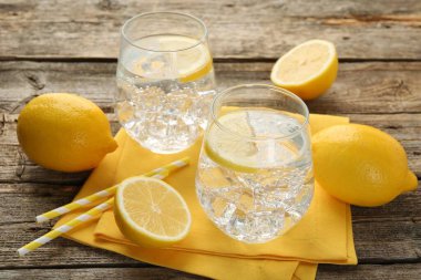 Limonlu, buzlu ve ahşap masadaki meyveli taze su, yakın plan.