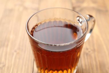 Ahşap masada fincanda siyah çay, yakın plan.