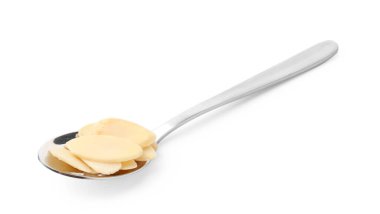 Kaşık içindeki taze badem taneleri beyaza izole edilmiş.