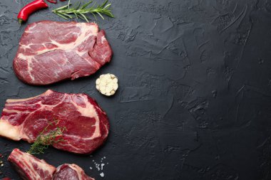 Çiğ et ve baharat parçaları siyah masada, düz yerde. Metin için boşluk