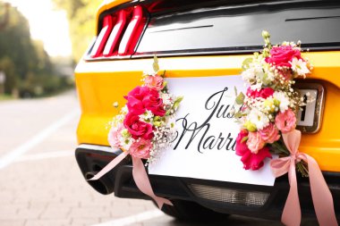 Düğün arabası. Cabriolet dekore edilmiş. Sadece evlilik kartı ve açık havada güzel çiçekler, yakın plan.