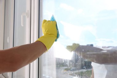 Pencere temizleyen bir adam, kapalı alanda, yakın plan. Metin için boşluk