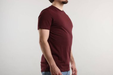 Açık gri arka plan yakınlarında şık kahverengi tişörtler giyen genç adam, yakın plan. Tasarım için model