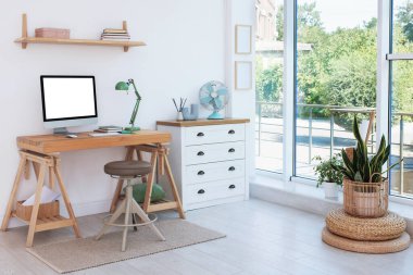 Evde rahat bir iş yeri. Odada bilgisayar olan bir masa