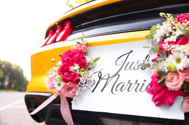 Düğün arabası. Cabriolet dekore edilmiş. Sadece evlilik kartı ve açık havada güzel çiçekler, yakın plan.