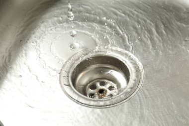 Water going down sink drain, closeup view