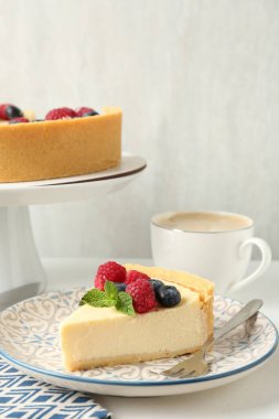 Taze böğürtlenli ve beyaz masada servis edilen nefis peynirli kek.