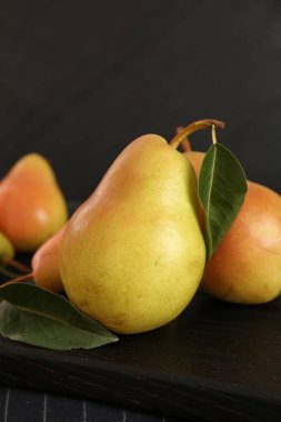 Masada taze armut ve yapraklar var. Yakın plan.