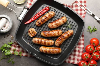 Izgara sosis, baharat ve domatesli tava gri desenli masa, düz uzanma