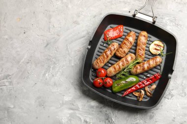 Izgara sosis, sebze, mantar ve baharatlı tava. Gri desenli masa, üst manzara. Metin için boşluk