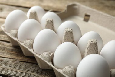 Ahşap masada çiğ tavuk yumurtası, yakın plan.