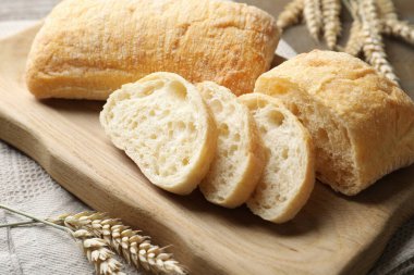 Taze çıtır ciabatalar ve buğday kulakları masada, yakın plan.