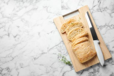 Çıtır ciabatta, bıçak ve kekik beyaz mermer masa, üst manzara. Metin için boşluk