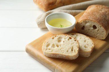 Taze çıtır ciabatalar ve biberiyeli beyaz ahşap masa, yakın plan. Metin için boşluk