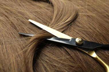 Güzel kahverengi saçlı makas, yakın plan.