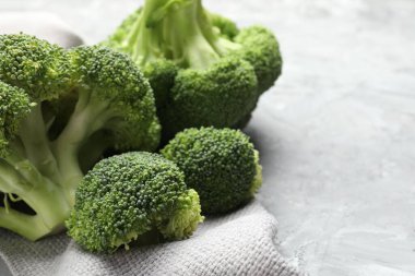 Fresh raw broccoli on gray textured table, closeup. Space for text