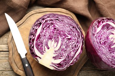 Tahta masada taze kırmızı lahana ve bıçak yarımları, düz yatıyordu.