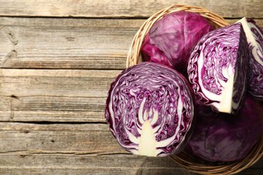 Hasır sepetin içinde ahşap masanın üstünde taze kırmızı lahanalar var. Metin için boşluk