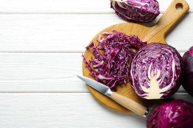 Tam ve kırmızı lahanalar, beyaz ahşap masada bıçak, düz yatış. Metin için boşluk