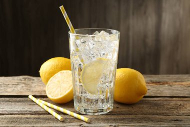 Limonlu, buzlu ve ahşap masada meyveli taze su.