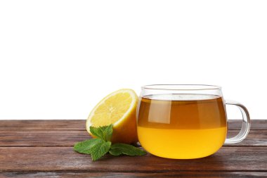 Beyaz arkaplana karşı ahşap masada limonlu ve naneli Aromatik çay, metin için yer
