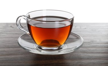 Beyaz arka planda koyu ahşap masada bir fincan aromatik siyah çay.