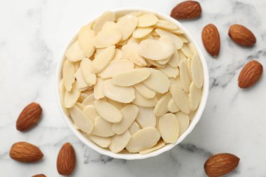 Taze badem gevrekleri ve beyaz mermer masada fındıklar.