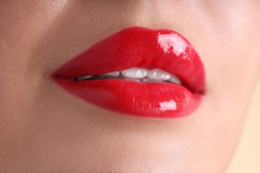 Dudaklarında güzel kırmızı ruj lekesi olan kadın bej arka planda, makro manzaralı.