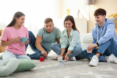 Bir grup arkadaş içeride iskambil oynuyor.