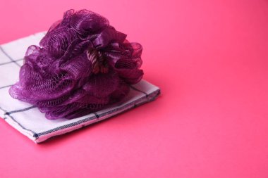 Pembe arka planda mor duşlu puf ve havlu, metin için boşluk