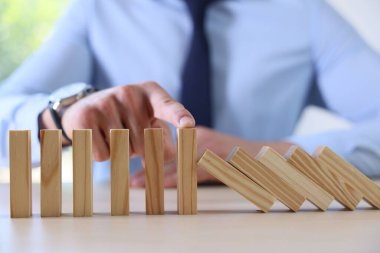 Risk. Masada domino etkisini durduran adam, yakın plan.