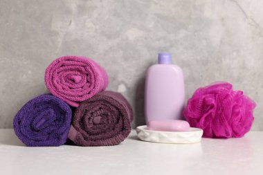Taze rulo havlular ve kozmetik ürünler beyaz masada, yakın plan.