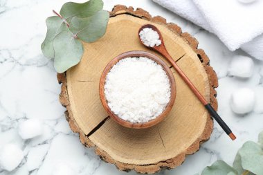 Kasede deniz tuzu, kaşık, havlu ve okaliptüs yaprakları beyaz mermer masa üzerinde düz yatıyordu.