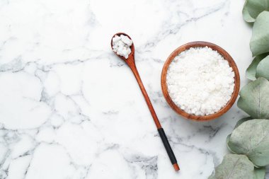 Deniz tuzu kasede, kaşıkta ve okaliptüs dalında beyaz mermer masada, düz yerde. Metin için boşluk