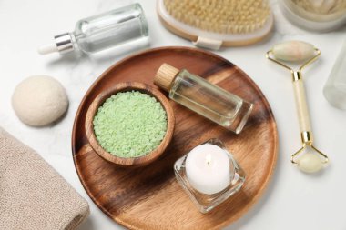 Beyaz mermer masa üzerinde farklı spa ürünleri içeren kompozisyon, üst görünüm