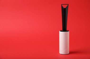 Kırmızı arkaplanda bir iplik silindiri, metin için boşluk