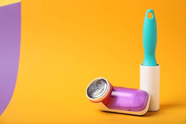 Renk arkaplanı üzerindeki iplik silindiri ve kumaş traş makinesi, metin için boşluk