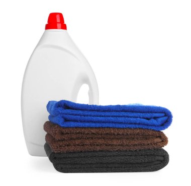 Çamaşır deterjanıyla dolu bir şişe ve beyaza izole edilmiş giysiler.