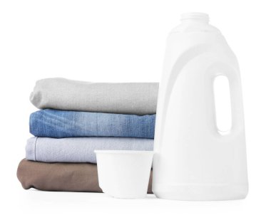 Çamaşır deterjanı, kep ve üst üste dizilmiş giysilerle dolu bir şişe.