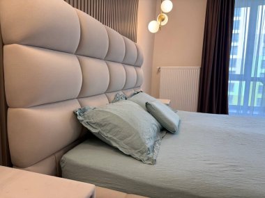 Yatak odasında yumuşak yastıkları olan rahat bir yatak.