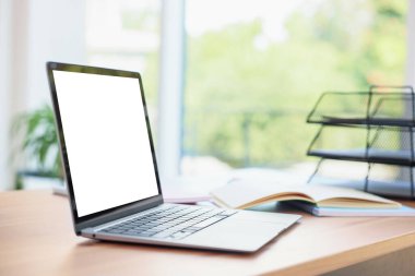 Odadaki boş beyaz ekranlı dizüstü bilgisayar. Rahat ev işyeri