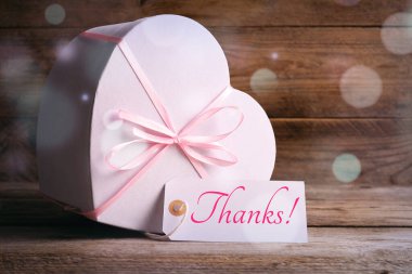 Teşekkürler etiket ve hediye paketi ahşap masada. Bokeh ışıkları